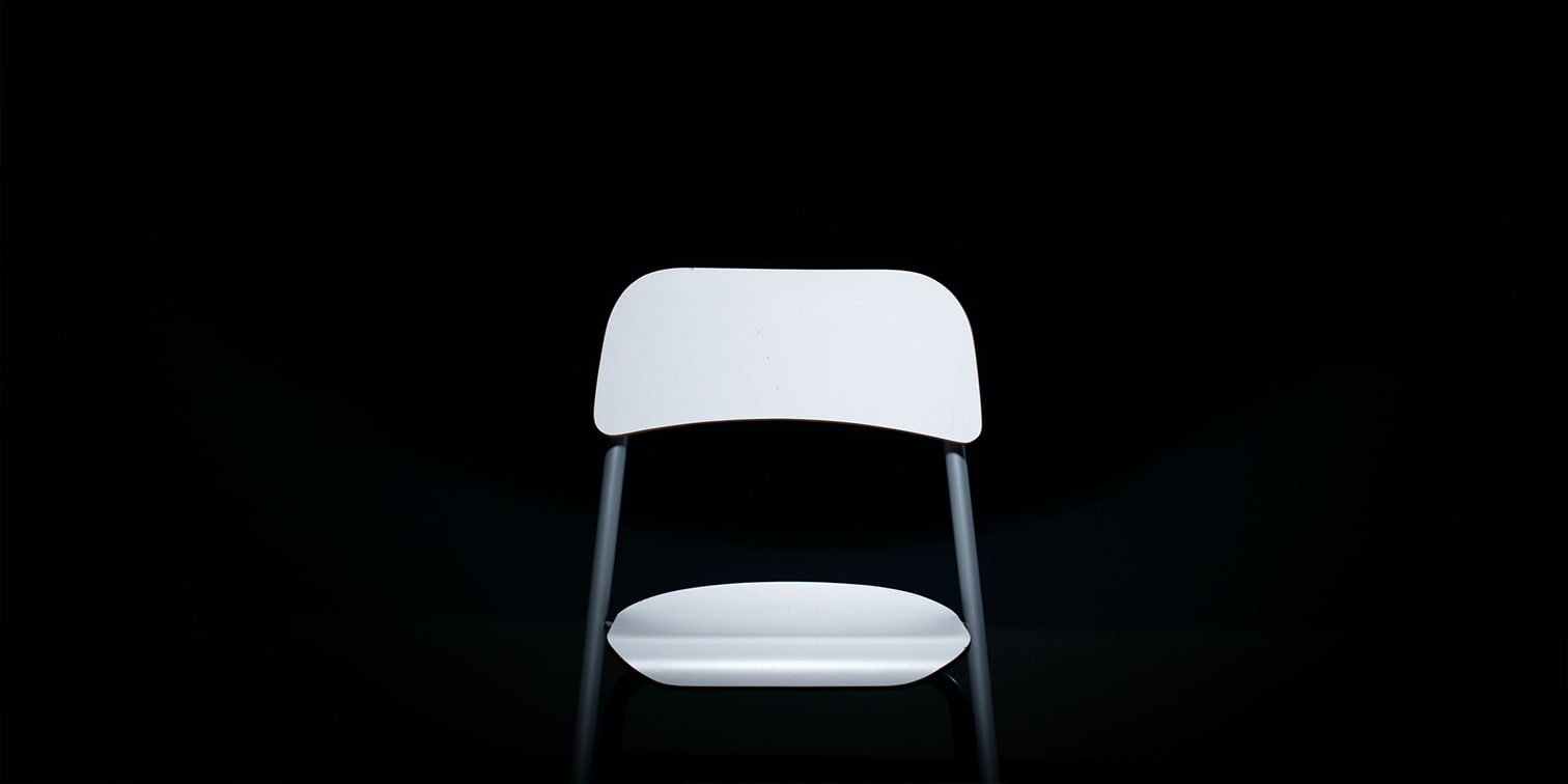An empty chair in a dark background before a deposition
