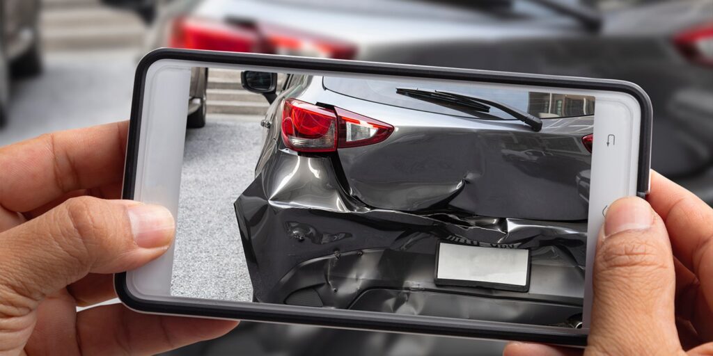 Person taking a photo of a car accident to use as evidence