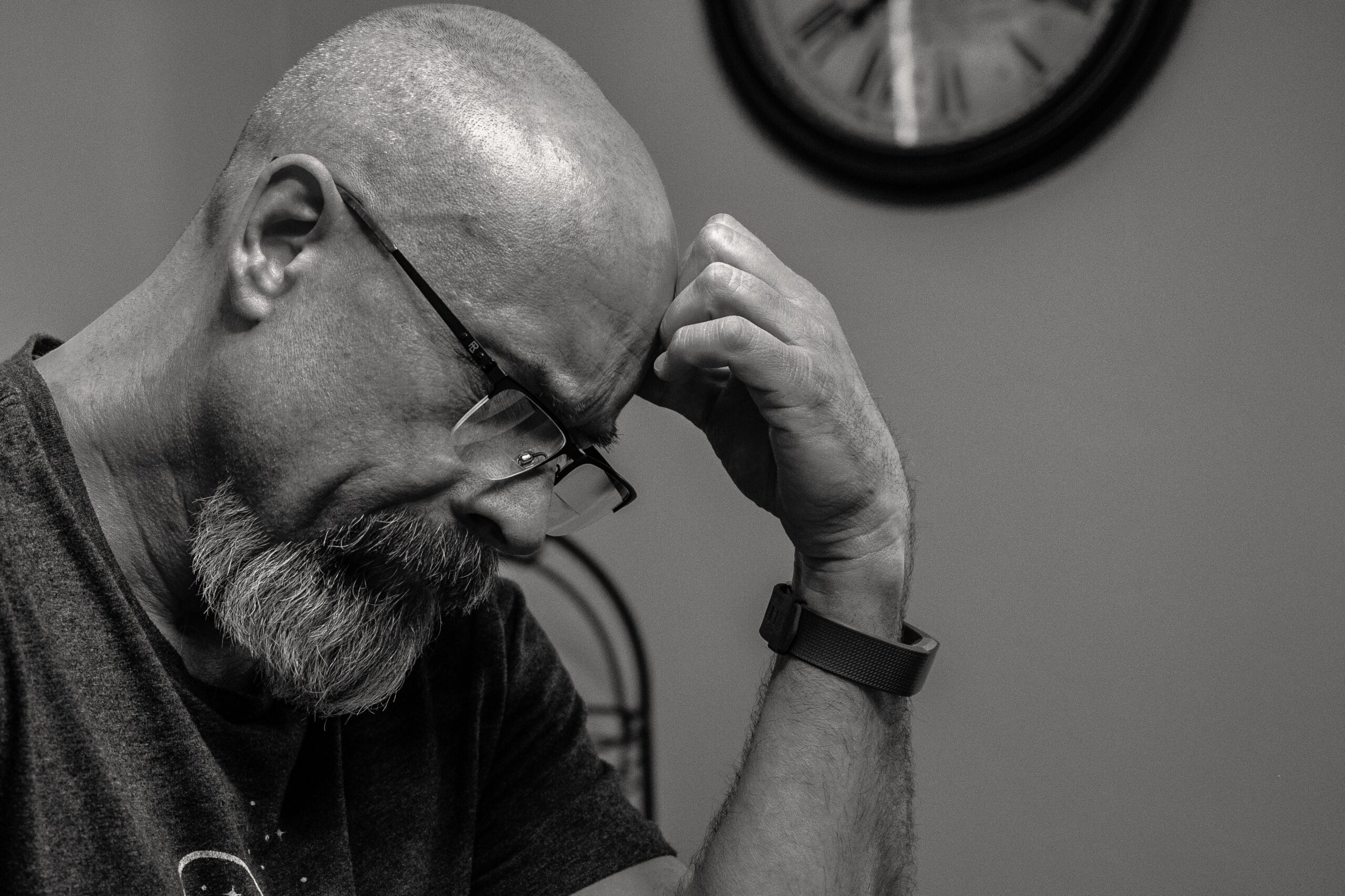 A man thinking in front of analog clock