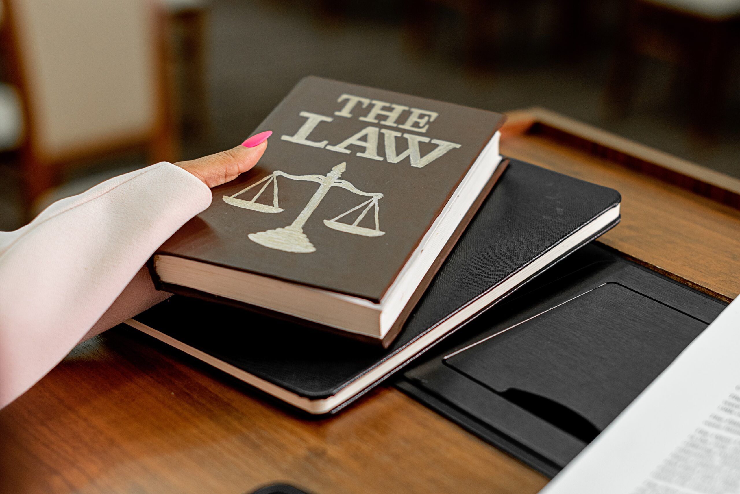 An attorney holding book with "THE LAW" boldly written on it