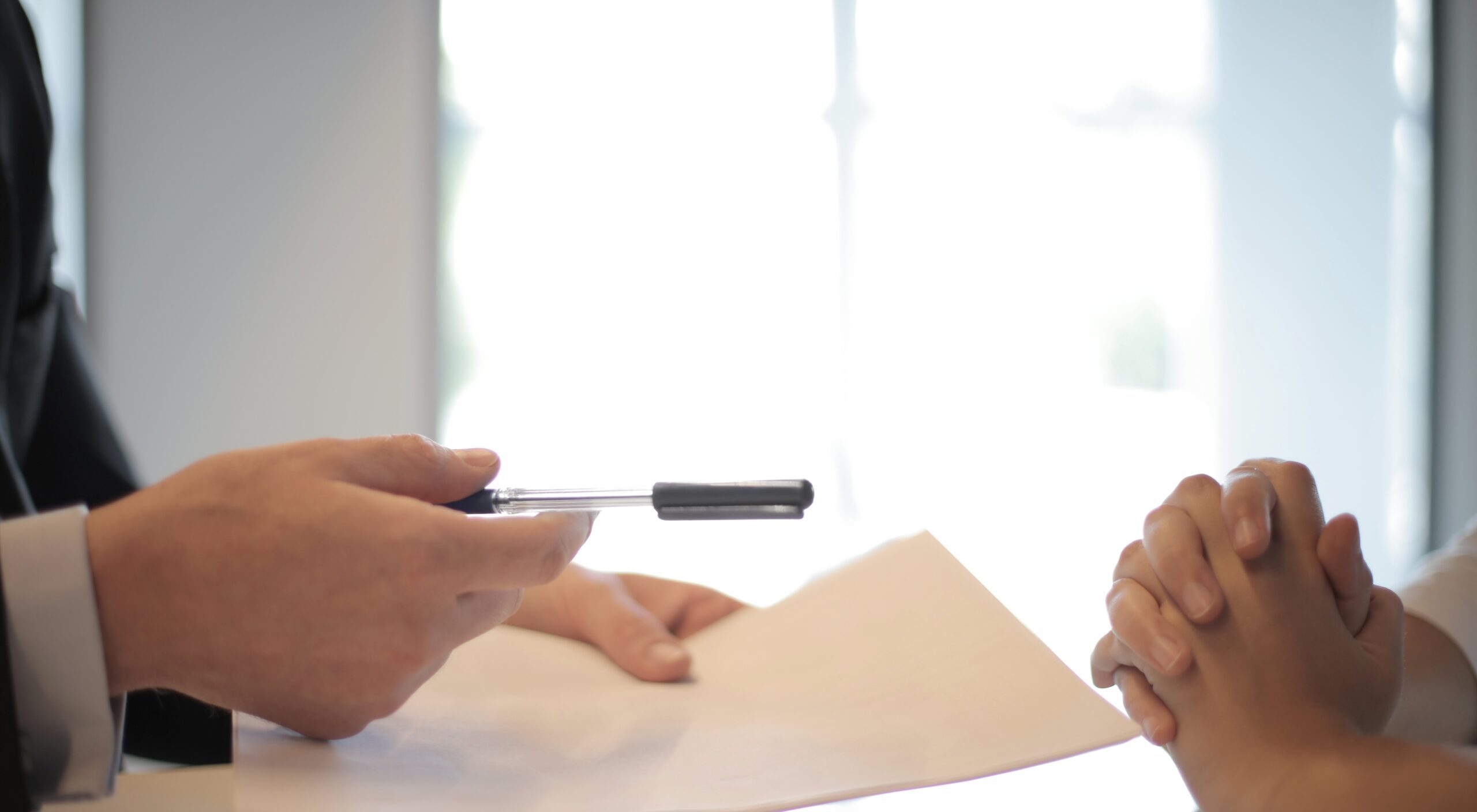 A man holding a pen and paper explaining things to someone