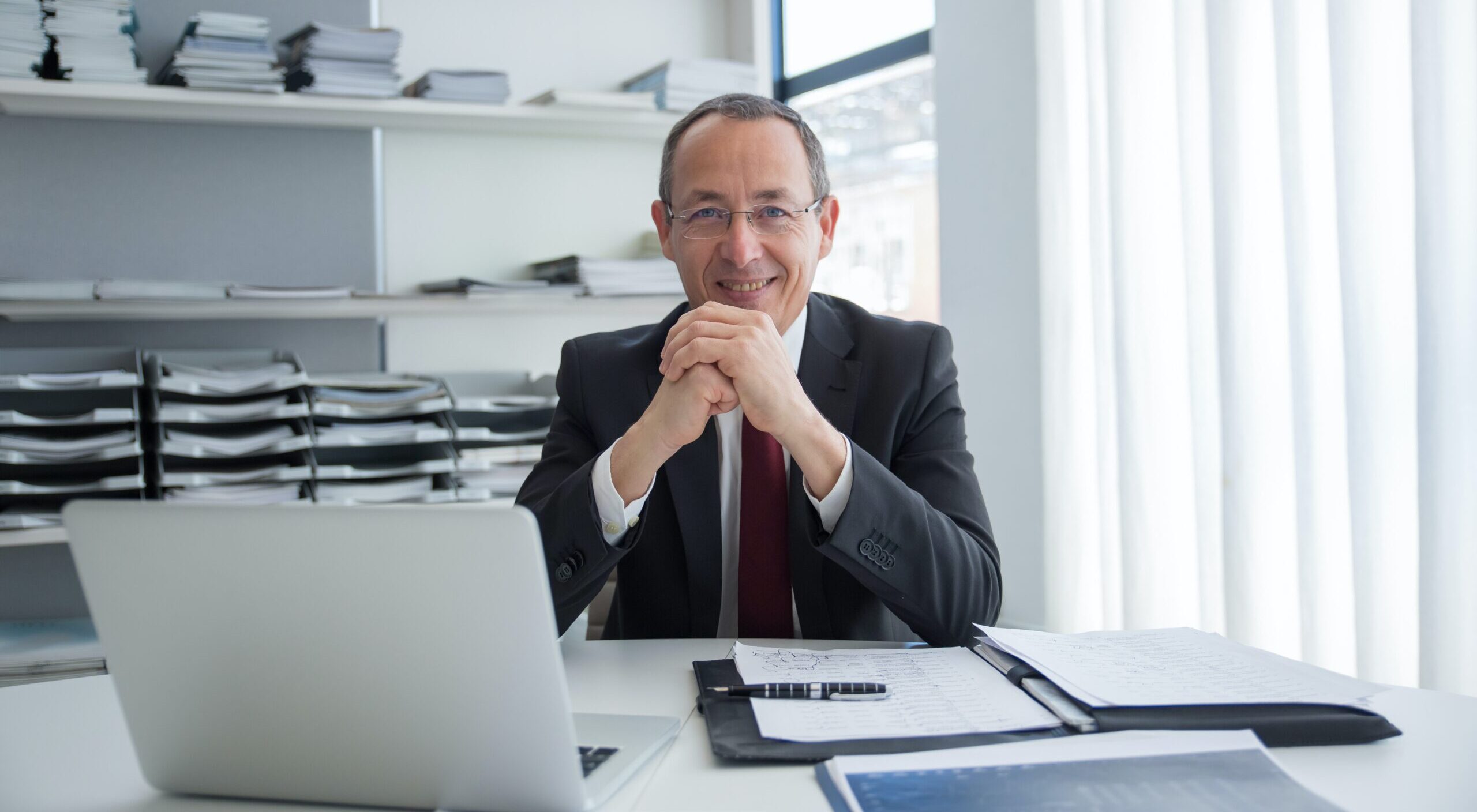 A lawyer sitting behind a laptop in his office