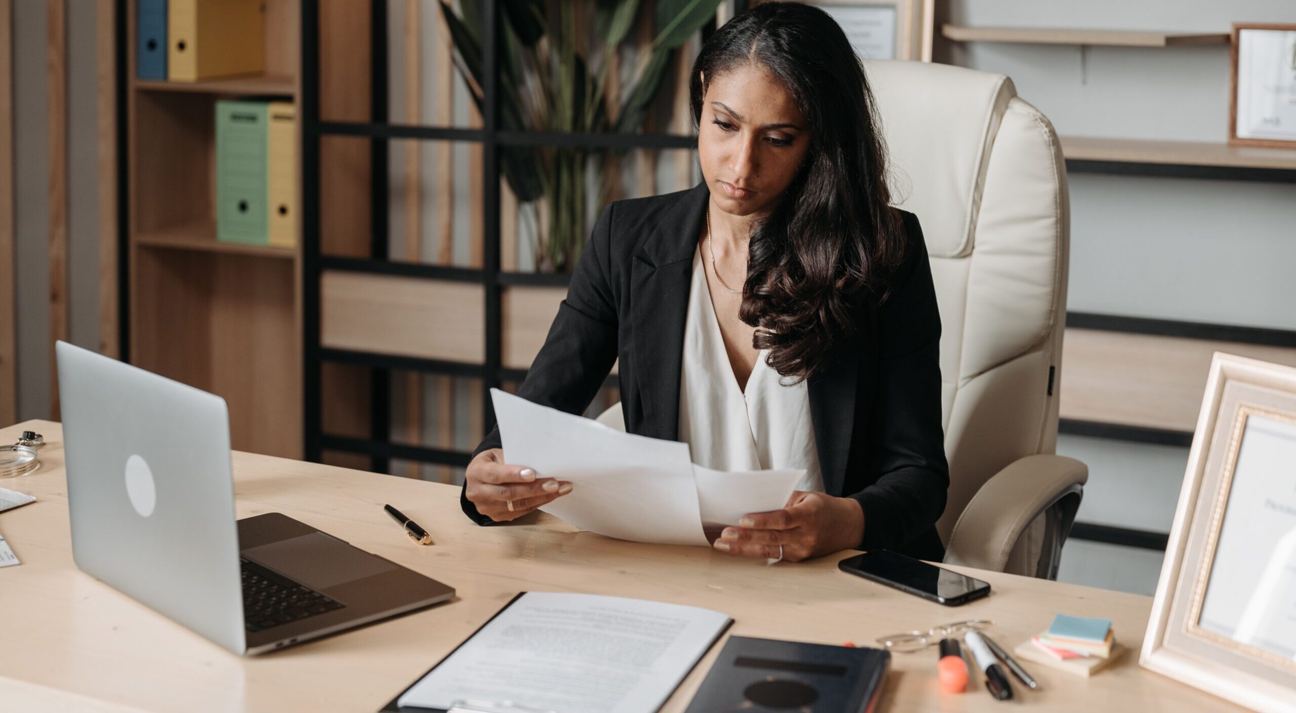 A young woman looking at document in her law office