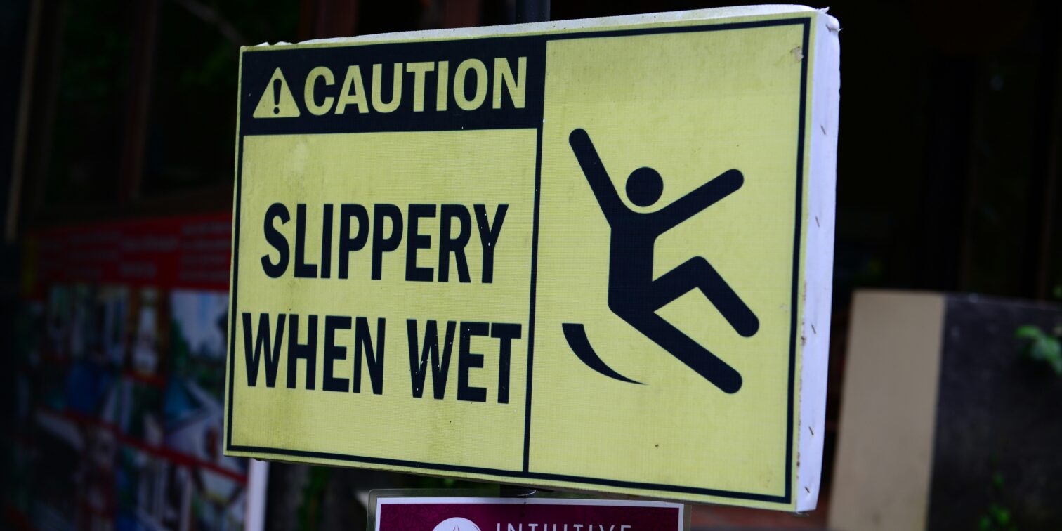 Caution sign showing wet floor in grocery store aisle