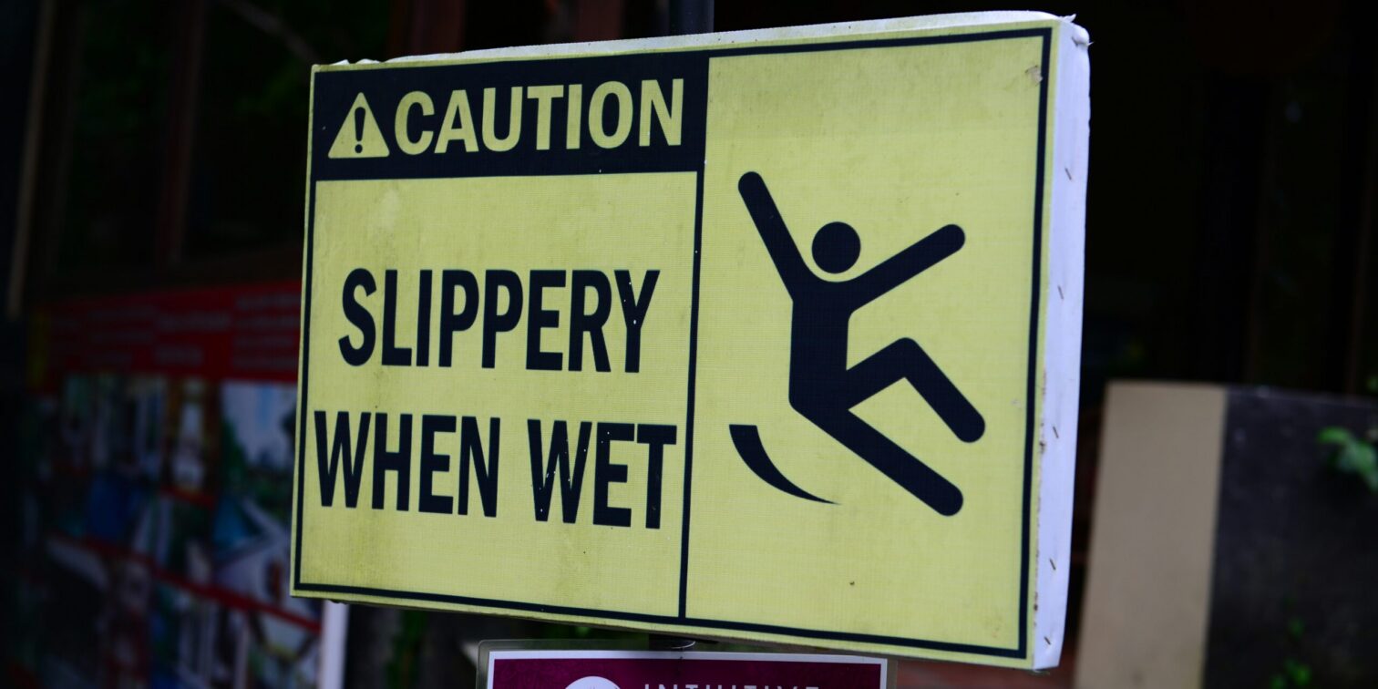 Caution sign showing wet floor in grocery store aisle